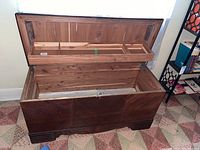 Front angle showing open lid with cedar lining and storage compartments in lid.