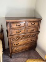 Front and side view of vintage Malcolm wood five drawer dresser, showing metal pull handles and carved leg feet.