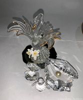 Clear Swarovski crystal swan with gold accents, penguin, clam shell figurines with pearls displayed on white background