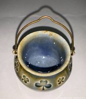 Top view of the miniature pot showing embossed shamrocks and metal handle