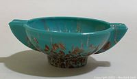 Turquoise Murano glass bowl with copper speckles, shown from side angle.
