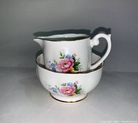 Side view of Queen Anne creamer inside sugar bowl showing floral patterns and gold trim.