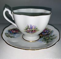 Front view showing floral design on teacup and matching floral saucer with gold trim