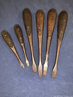 Full view of the 6 vintage screwdrivers laid flat showing wooden handles and metal shafts with varying blade sizes