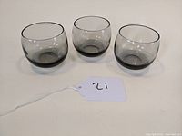 Three smoke colored rolypoly tumblers shown from front angle, showing shape and color.