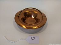 Copper bowl front view showing hammered texture and concave shape with broad rim