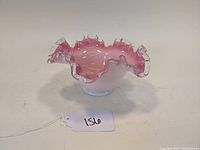 Front angle view of pink cased glass Silver Crest ruffled edge bowl with clear tipped rim showing smooth finish and rounded shape.