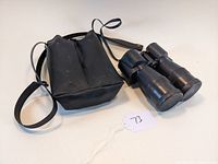 Vintage Von Zeitch binoculars with carrying case and neck strap laid flat on white background.