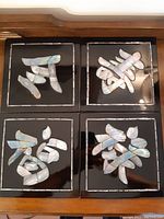 Overview of all four Asian inspired decorative black tiles with mother of pearl inlay characters.