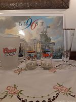 Full view of all drinking glasses, pitcher and Brest 96 placemats, displayed on embroidered fabric surface.
