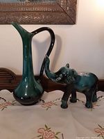 Full view of both the Blue Mountain Pottery tall pitcher and elephant figurine side by side, showing size and matching glaze colors.