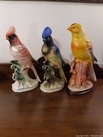Three bird figurines side by side showing color and detailed painting