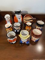 Collection of nine assorted Toby mugs, varied sizes from about 1.5 to 5 inches, depicting characters in historical and uniform attire, mostly Occupied Japan porcelain.