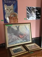 Five wall art pieces displayed on pink and dark wallpapered wall: three framed bird prints on lower half, two cat posters on upper half