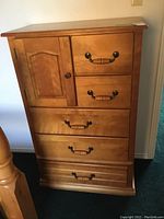 Front view of the dresser showing four drawers and a side cabinet door with wooden handles