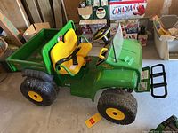 Side view showing entire ride-on tractor including body, seats, wheels and cargo bed.