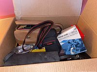 Box containing various vintage cameras and accessories including Canon case, Pana-vue slide viewer box, and leather camera case