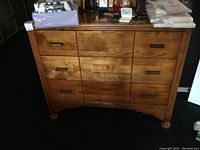 Front view of vintage wood dresser showing three drawers with rectangular wooden handles.
