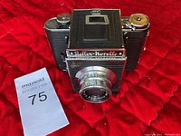 Franka-Korelle Reflex camera front view on red quilted fabric showing lens, Reflex-Korelle nameplate and waist-level finder housing