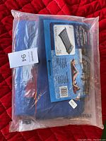 Photo of new in bag blue Campingaz air mattress in original plastic packing with informational label.