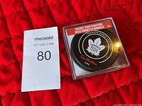 Plastic case containing a hockey puck coaster with Toronto Maple Leafs logo and Tim Hortons branding.