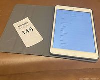 Photo of Apple iPad in blue folio case, powered on to setup screen showing country selection.