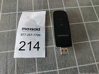 Front side of Linksys wireless USB adapter showing 'LINKSYS' branding in black and USB connector visible.