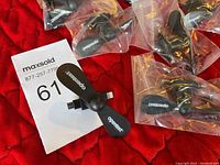 Close-up of a single mini black fan with two blades, each printed with 'opentext', plugged into a smartphone charging port connector.