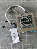 PC power supply unit visible from top, showing large fan and attached cables with connectors.