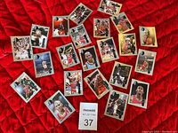 Photo showing 19 Michael Jordan basketball trading cards spread thick over red blanket background, showing a variety of Upper Deck cards including several different images of Jordan in action.