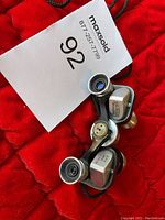 Photo of vintage binoculars with visible eyepieces, focusing wheel, and attached neck strap.