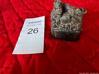 Front view of the vintage Chinese buffalo horn sculpture showing detailed carvings of two buffalo with a central sphere on a textured base.