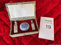 Set of vintage Chinese ink pad and two carved stamps placed inside decorative fabric-covered box with red velvet lining.