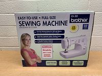Box front showing Brother LS-30 sewing machine image, features such as free arm sewing surface, automatic bobbin winding system, 3 needle position selector, 22 functions, and 25 years limited warranty.