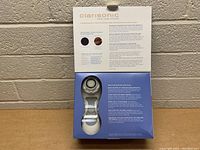 Photo showing Clarisonic Skin Care System brush inside open box with product information on inside lid.