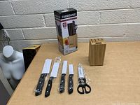 The new 6 piece Farberware cutlery set showing knives still in plastic packaging alongside the wooden knife block and product box.