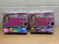 Photo showing two unopened Bratz mini keyboards with vibrant pink keys, labeled for PC compatibility through USB port, with holographic packaging featuring Bratz cartoon art.