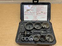 Open view of the Mac Tools hole saw kit showing nine bi-metal hole saws and arbors in the molded case.
