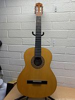 Front view of Montana classical guitar with natural wood finish showing guitar body, fingerboard, and slotted headstock.