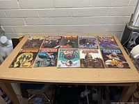 Eleven vintage EERIE horror comics laid out on a table showing colorful illustrated covers with horror and sci-fi themed images.