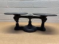 Front view of vintage cast iron balance scale showing the two round pans and sturdy base