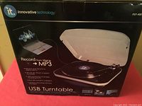 Box showing the product image and brand 'Innovative Technology ITUT-400' with the product open to display turntable design and USB functionality.