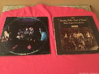 Photo of both vintage LP album covers placed side by side on a flat surface showing wear on covers and group images.