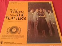 Front cover of The 50 Golden Hits of The Platters LP box set showing group photo and title.