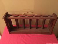 Front and top view showing six bottle slots and rope handle.