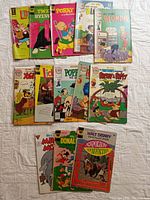 Lot of 14 vintage comic books laid out on a white surface, showing cover art of various classic Hanna Barbera and Disney characters such as The Flintstones and Blondie, along with other titles.