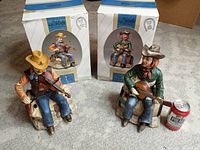 Photo of both figurines displayed next to their original packaging boxes and a soda can for size reference.