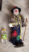 Full doll standing on the floor showing clothing, face, and stand.
