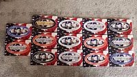 Front view of 14 American flag-themed boxes of State Quarters collections, arranged in rows.