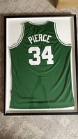 Full view of the framed Paul Pierce jersey showing the back with name 'PIERCE' and number '34' in white on green fabric.